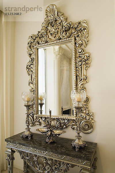 Detail eines dekorativen Spiegels über einem kleinen Beistelltisch