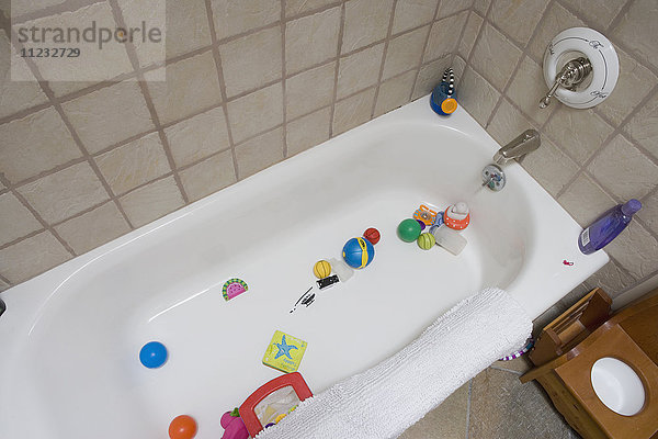 Detail einer mit Babyspielzeug gefüllten Badewanne