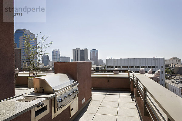 Grillplatz auf der Terrasse mit Stadtblick im Hintergrund.