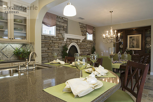 Küche mit Frühstücksbar und Esszimmer mit Steinwand