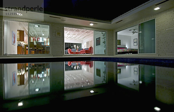 Nachtansicht in Richtung Wohnzimmer des Hauses über den Pool