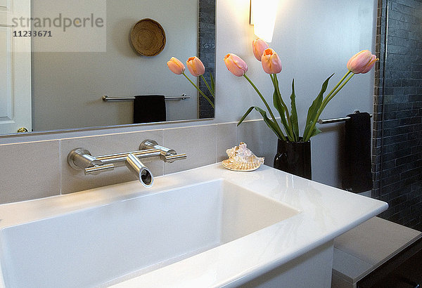 Weißes modernes Waschbecken mit rosa Tulpen