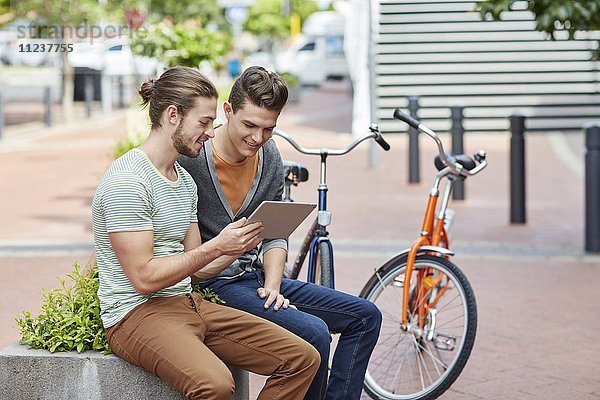 Zwei junge Männer mit digitalem Tablet