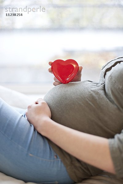Schwangere Frau mit Herzform auf dem Bauch