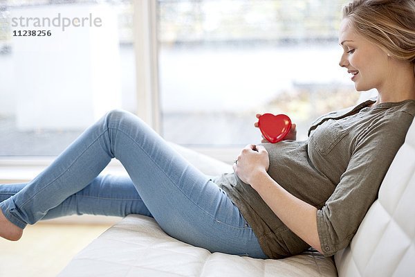 Schwangere Frau mit Herzform auf dem Bauch