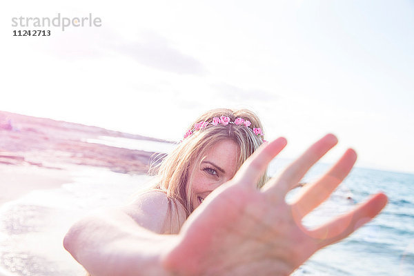 Frau mit bedecktem Gesicht am Strand