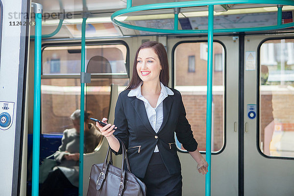 Geschäftsfrau reist im Zug der Docklands Light Railway  London