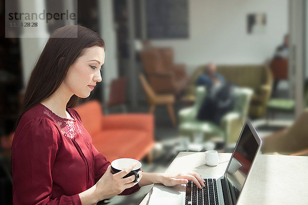 Geschäftsfrau arbeitet mit Laptop im Café