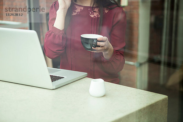 Geschäftsfrau arbeitet mit Laptop im Café