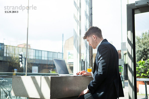 Geschäftsmann arbeitet mit Laptop im Café