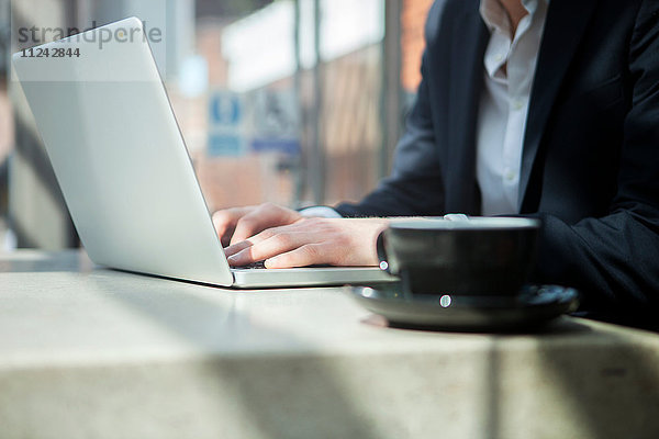 Geschäftsmann arbeitet mit Laptop im Café