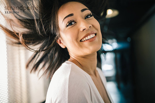 Junge Frau mit schwingenden Haaren  lächelnd