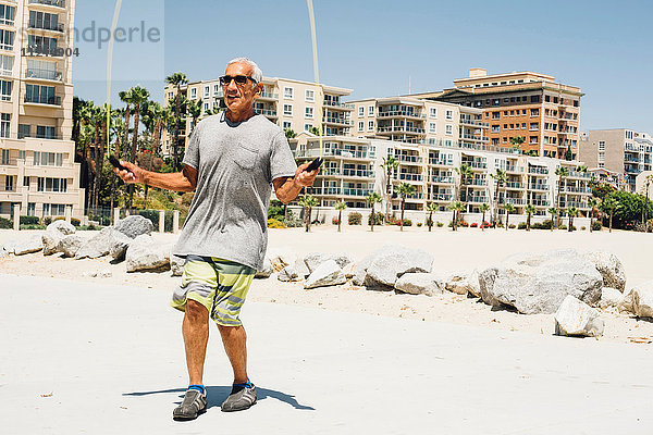 Älterer Mann  Hüpfen am Strand  Long Beach  Kalifornien  USA