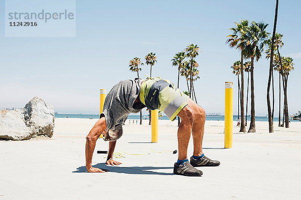 Älterer Mann  am Strand trainierend  in Yogastellung  Long Beach  Kalifornien  USA