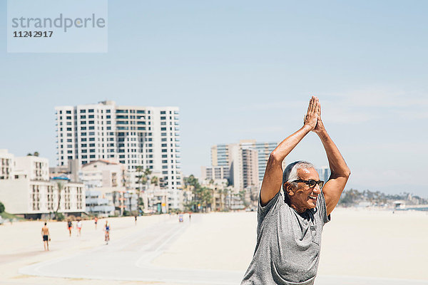 Älterer Mann  am Strand trainierend  in Yogastellung  Long Beach  Kalifornien  USA