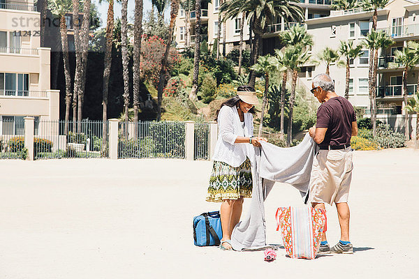 Älteres Ehepaar am Strand  legt Decke zum Picknick aus  Long Beach  Kalifornien  USA