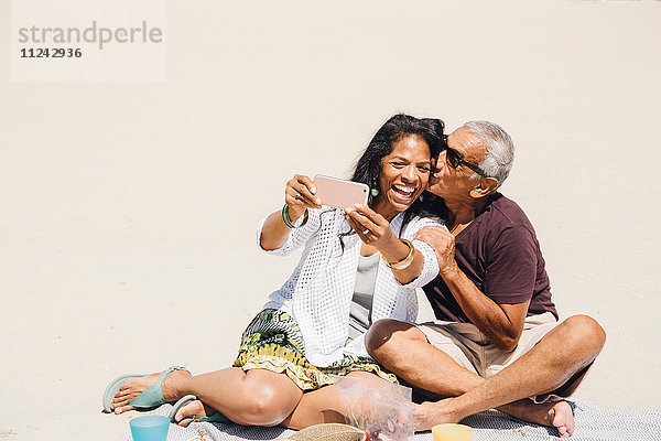 Älteres Ehepaar am Strand sitzend  Selfie mit Smartphone  Long Beach  Kalifornien  USA