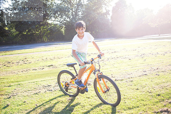 Junge fährt Fahrrad in der Sommersonne