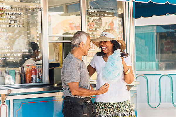 Älteres Ehepaar steht neben einem Erfrischungsstand und hält Zuckerwatte  Long Beach  Kalifornien  USA