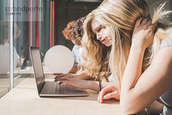 Mitarbeiter  die am Laptop neben dem Bartresen am Fenster arbeiten