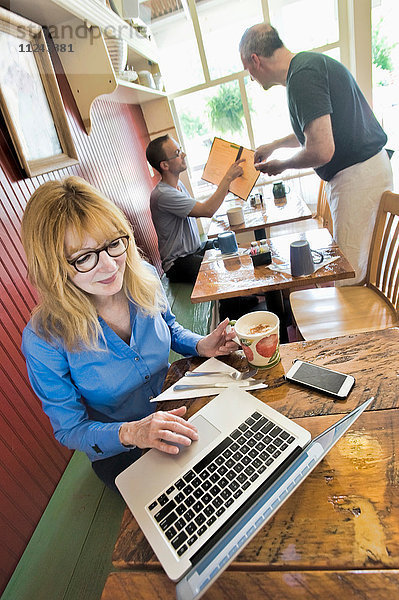 Frau benutzt Laptop im Café