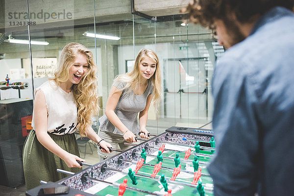 Mitarbeiter spielen in der Pause Tischfußball