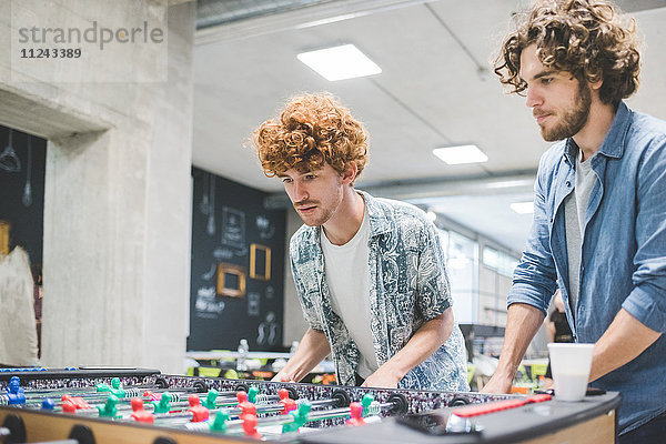 Mitarbeiter spielen in der Pause Tischfußball