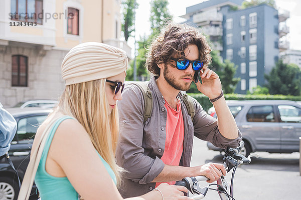 Pärchen mit Telefon und Laufen mit Push-Bikes