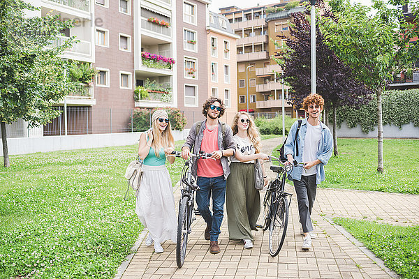 Freunde  die mit dem Fahrrad im Park spazieren gehen.