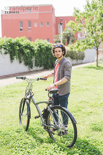 Mann mit Fahrrad im Park