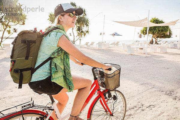 Junge Frau radelt am Strand  Gili Meno  Lombok  Indonesien