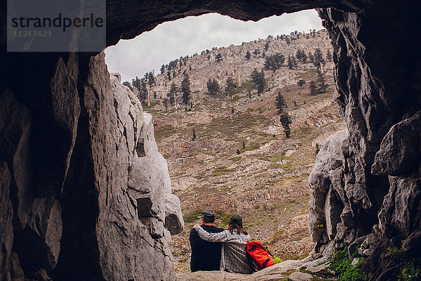 Zwei Wanderer sitzen neben der Höhle  Rückansicht  Mineral King  Sequoia National Park  Kalifornien  USA