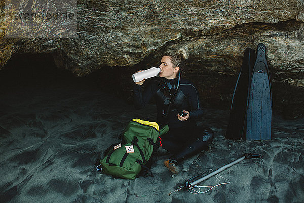 Taucher mit Speerwaffe am Strand ruhend  Big Sur  Kalifornien  USA