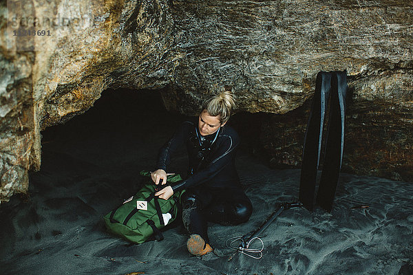 Taucher mit Speerwaffe am Strand ruhend  Big Sur  Kalifornien  USA