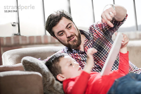 Vater und Sohn nutzen das digitale Tablett zu Hause