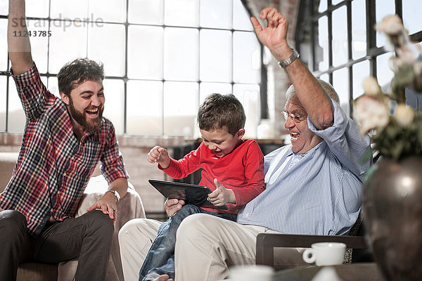 Drei-Generationen-Familie mit digitalem Tablett zu Hause