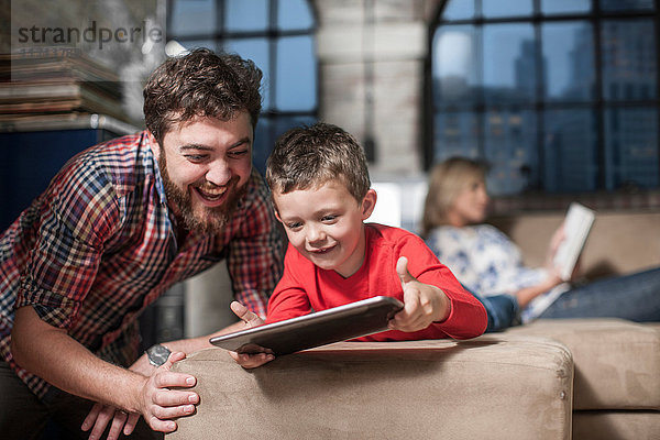 Vater und Sohn nutzen das digitale Tablett zu Hause