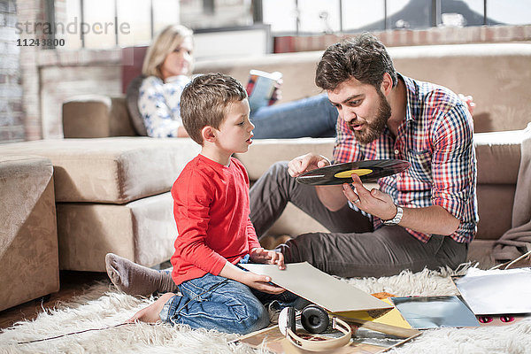 Vater zeigt dem Sohn eine Schallplatte zu Hause