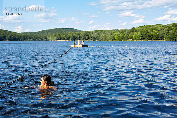 Junge Frau schwimmt im Sebago-See  New York  USA
