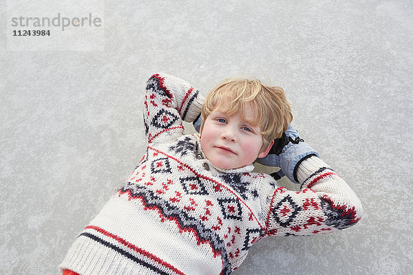 Portrait eines auf einem zugefrorenen See liegenden Jungen  Gavle  Schweden