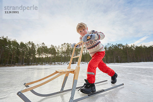 Junge schiebt Tritte über gefrorenen See  Gavle  Schweden