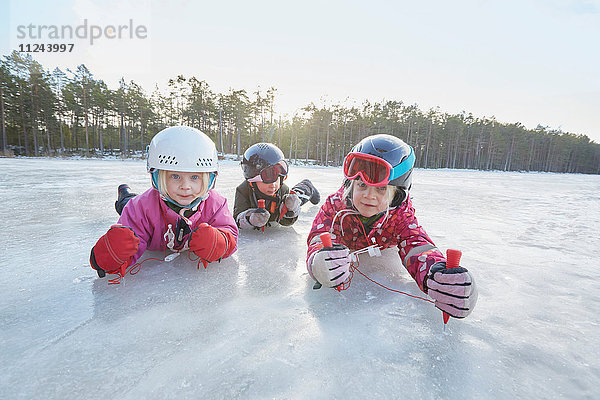 Porträt von Mädchen und Jungen  die auf dem gefrorenen See krabbeln  Gavle  Schweden