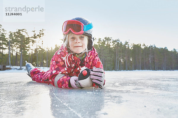 Porträt eines Mädchens  das auf dem gefrorenen See auf der Vorderseite liegt  Gavle  Schweden