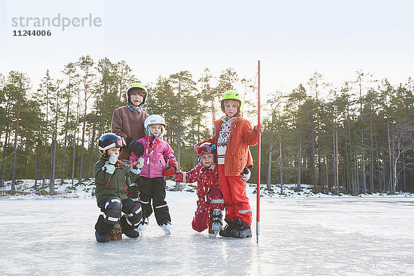 Porträt von Mädchen und Jungen mit Skihelmen auf dem zugefrorenen See  Gavle  Schweden