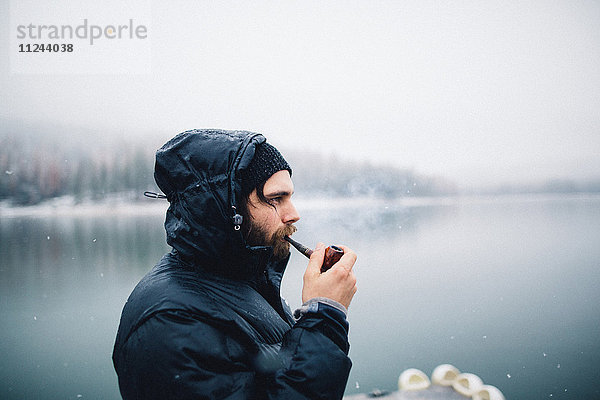 Seitenansicht eines Pfeife rauchenden Mannes am See  Bass Lake  Kalifornien  USA