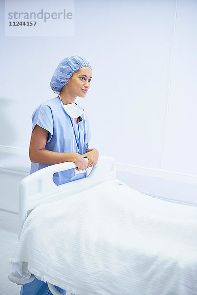 Krankenschwester steht am Krankenhausbett
