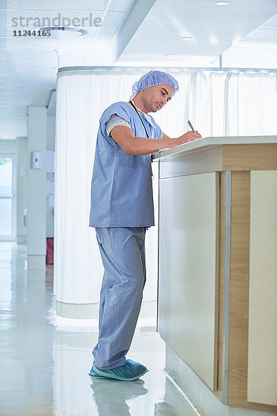 Arzt schreibt medizinische Notizen auf der Krankenschwesternstation