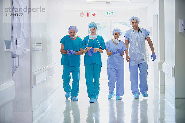 Vier medizinisches Personal in Kitteln im Krankenhauskorridor