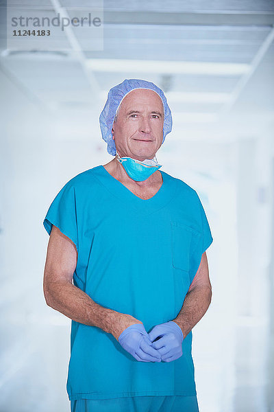 Porträt eines leitenden männlichen Arztes mit Kitteln im Krankenhauskorridor