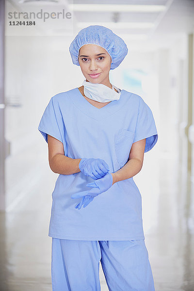 Porträt einer mittleren erwachsenen Ärztin mit Kitteln im Krankenhauskorridor